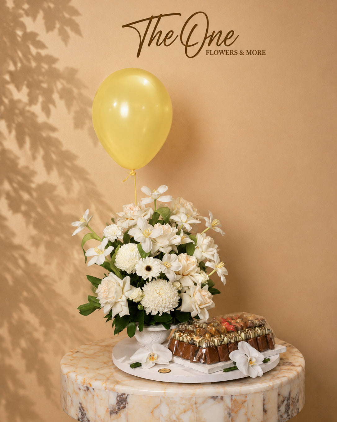 Luxury ivory and white flower arrangement with premium chocolates and balloon by The One Flowers with delivery across UAE