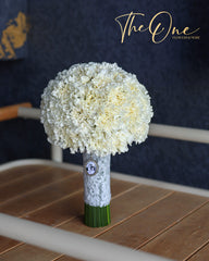 Ivory white bridal bouquet with round carnations and lace-wrapped stems by The One Flowers for weddings in UAE