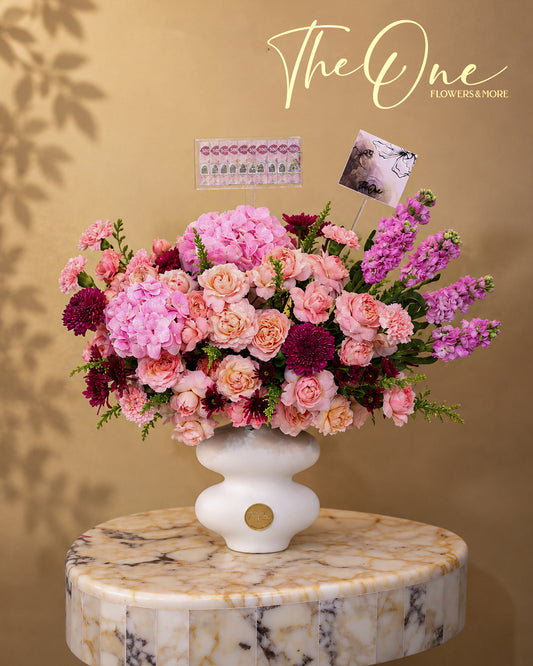 Luxury pink flower arrangement with roses, hydrangeas and seasonal blooms in a white vase by The One Flowers Al Ain UAE