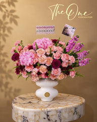 Luxury pink flower arrangement with roses, hydrangeas and seasonal blooms in a white vase by The One Flowers Al Ain UAE